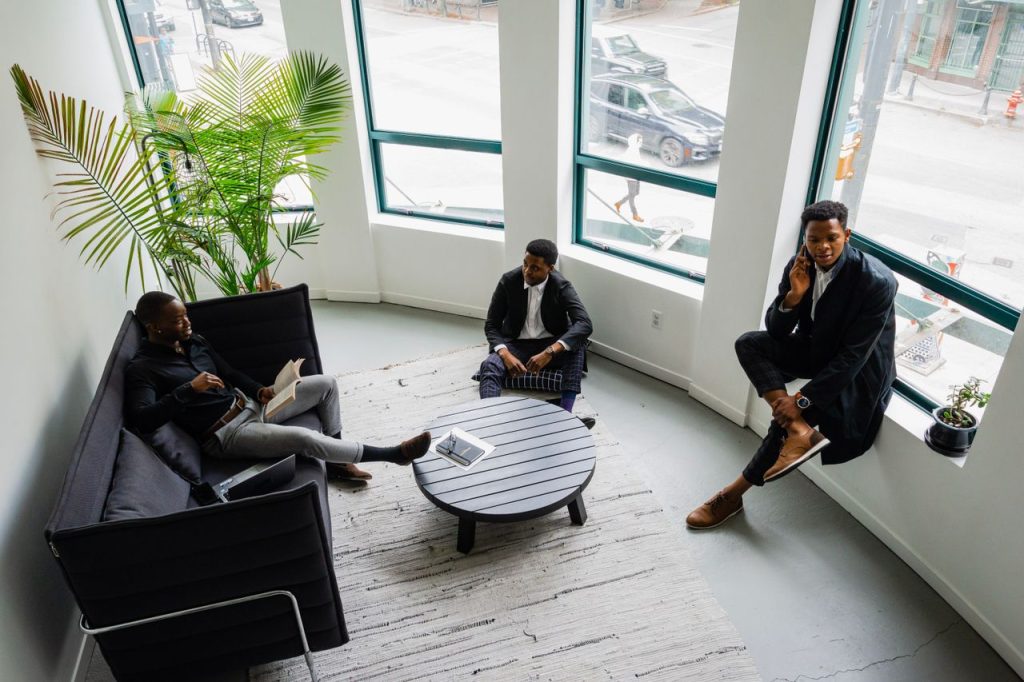 Three businessmen engaging in a professional meeting in a stylish office setting.